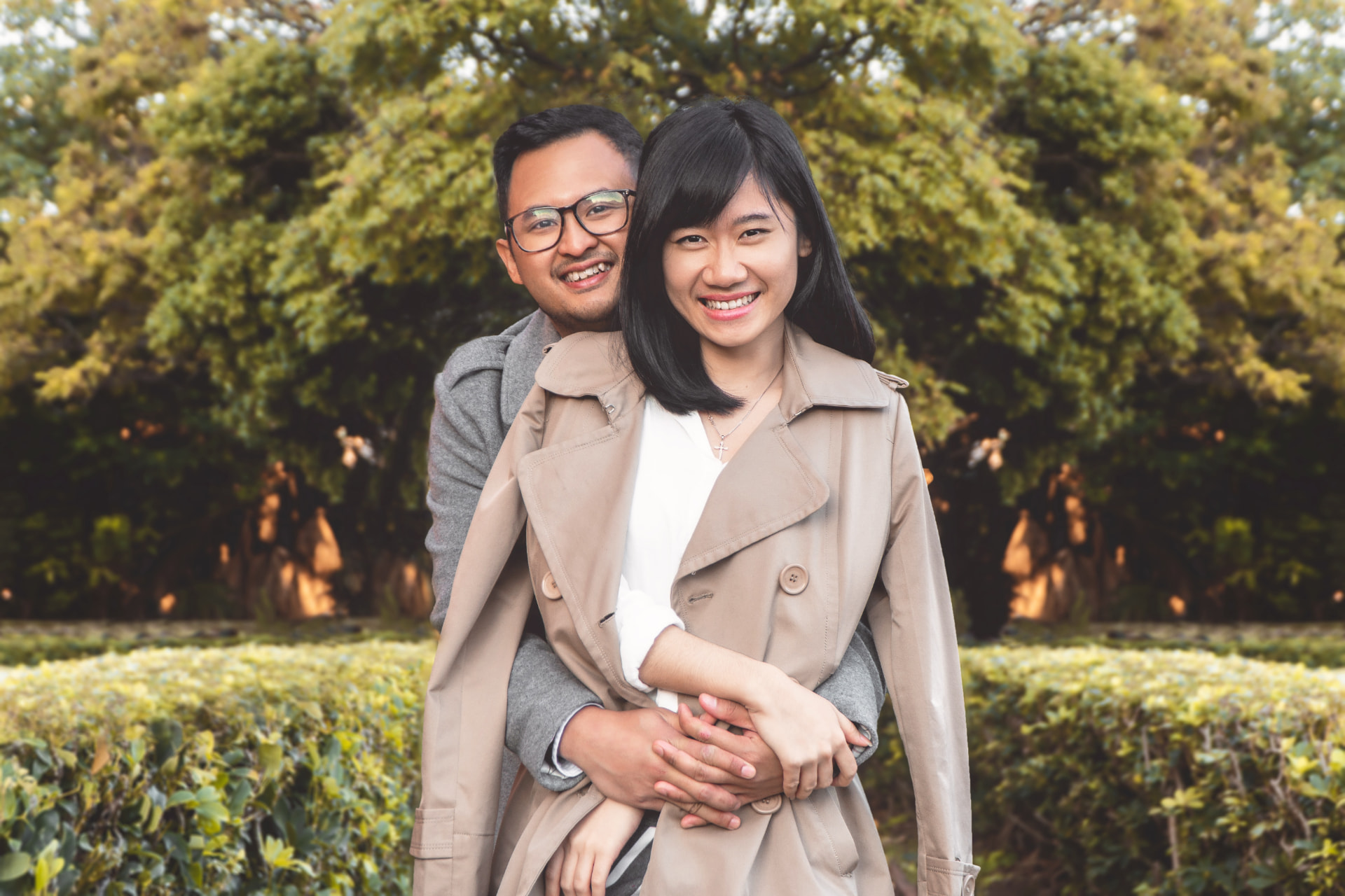 A smiling couple embracing in a sunlit park
